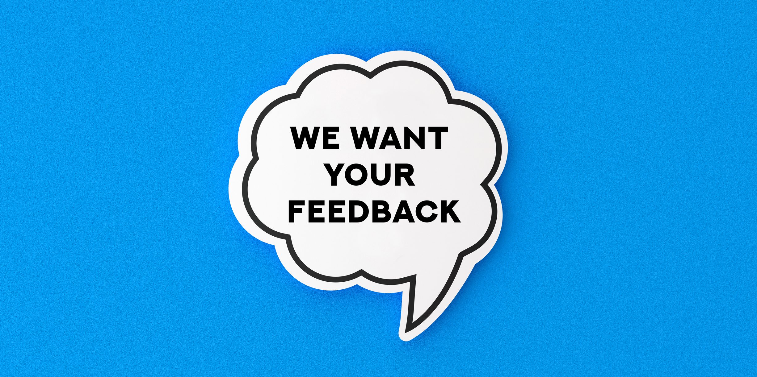 Speech Bubble and Blue Background That Says, We Want Your Feedback