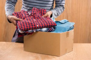 Donation box for poor with clothing in female male hands